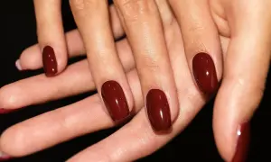 Dłonie z idealnie pomalowanymi na głęboki, wiśniowy kolor paznokciami. To zdecydowanie trendy paznokcie wiosenne, które dodają elegancji.