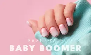 Dłoń z paznokciami w stylu baby boomer, delikatny gradient różu i bieli.