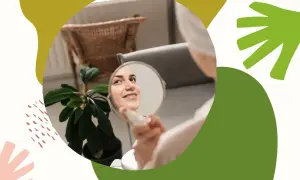 Kobieta z uśmiechem ogląda swoją cerę w lusterku, ciesząc się zdrowym wyglądem skóry.