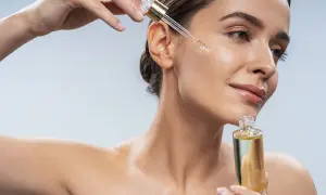Kobieta aplikuje serum na twarz. Zastanawiasz się, jaki peeling do twarzy wybrać? Ten olejek może być odpowiedzią.