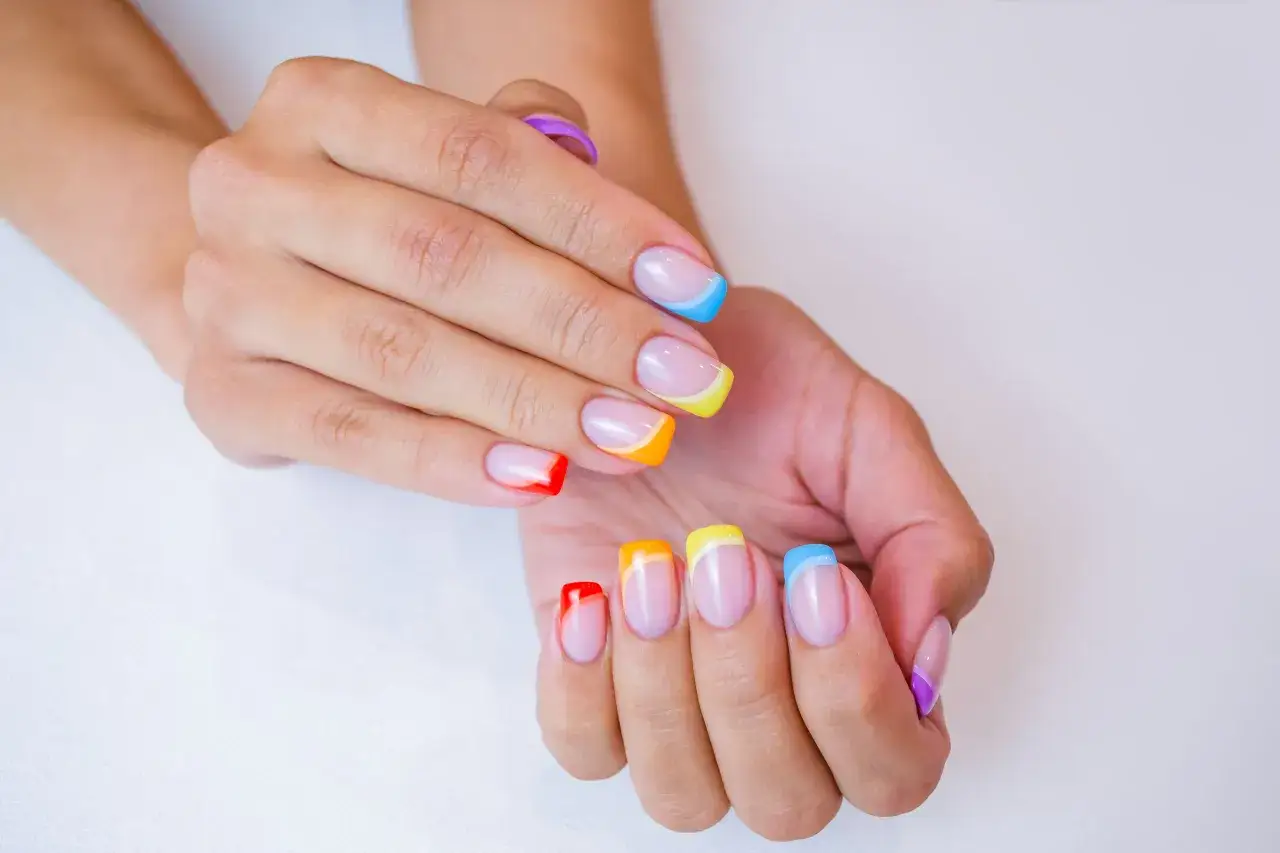 Kolorowy manicure na lato: paznokcie w odcieniach tęczy, idealne na wakacyjne dni.