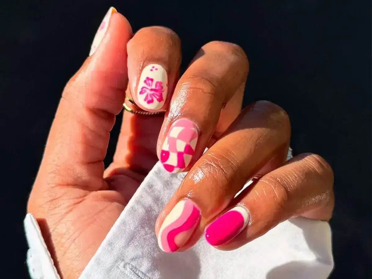 Kolorowe paznokcie w stylu retro, z kwiatami i geometrycznymi wzorami. Zastanawiasz się, ile schnie lakier do paznokci? Ten manicure wygląda świeżo!
